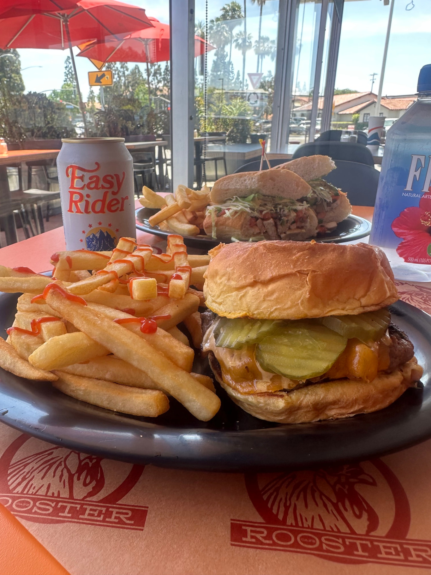 Cheeseburger with pickles and a basket of fries at Rooster Cafe